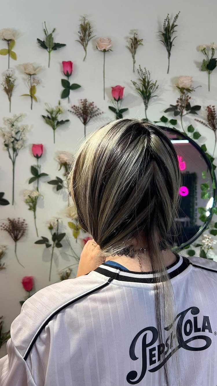 Short brown bob with chunky golden blonde highlights and dark shadow roots