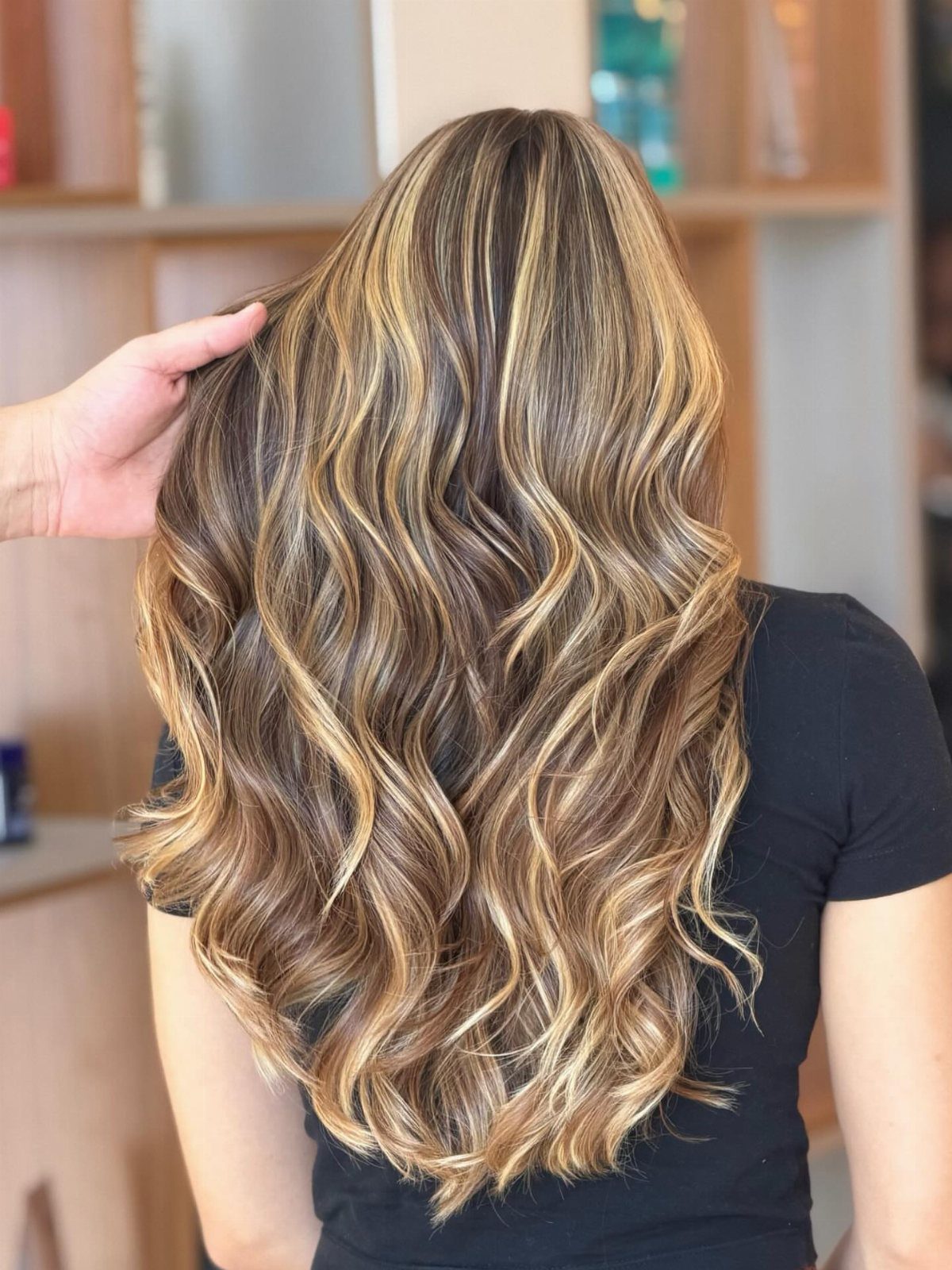 Long brunette curls with bright golden blonde highlights viewed from behind