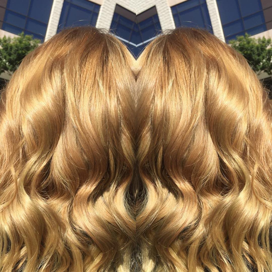 Long golden blonde waves with darker roots and lighter highlights