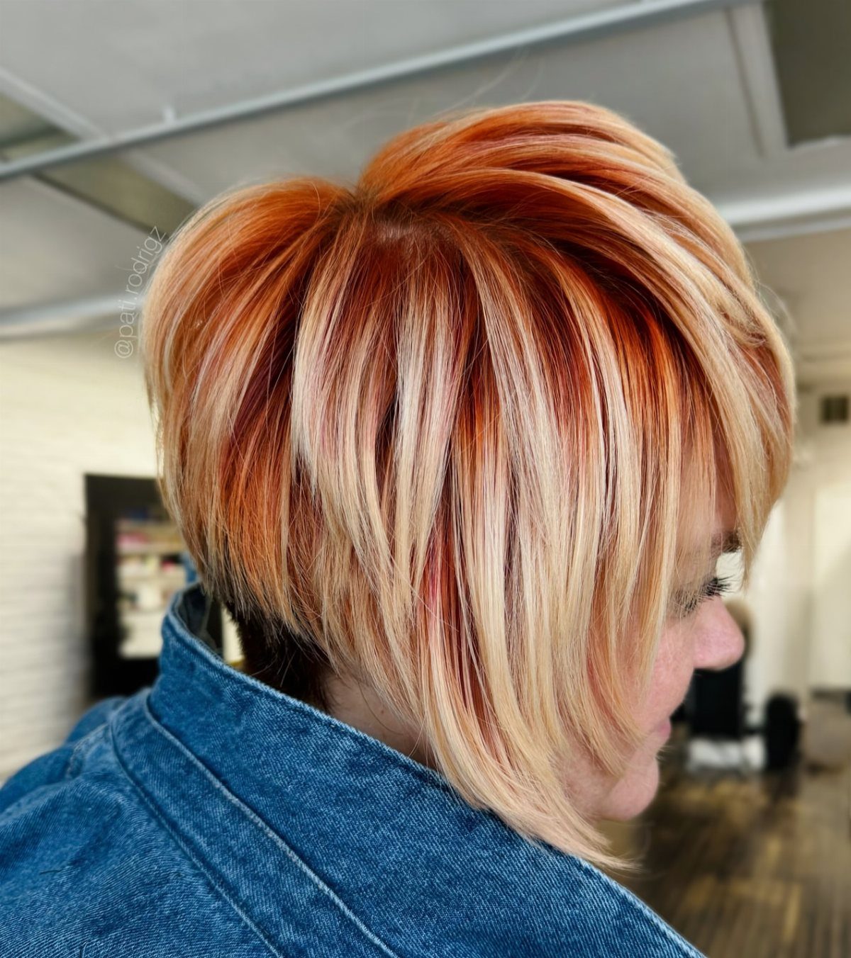 Angled pixie cut with copper roots and blonde balayage streaks