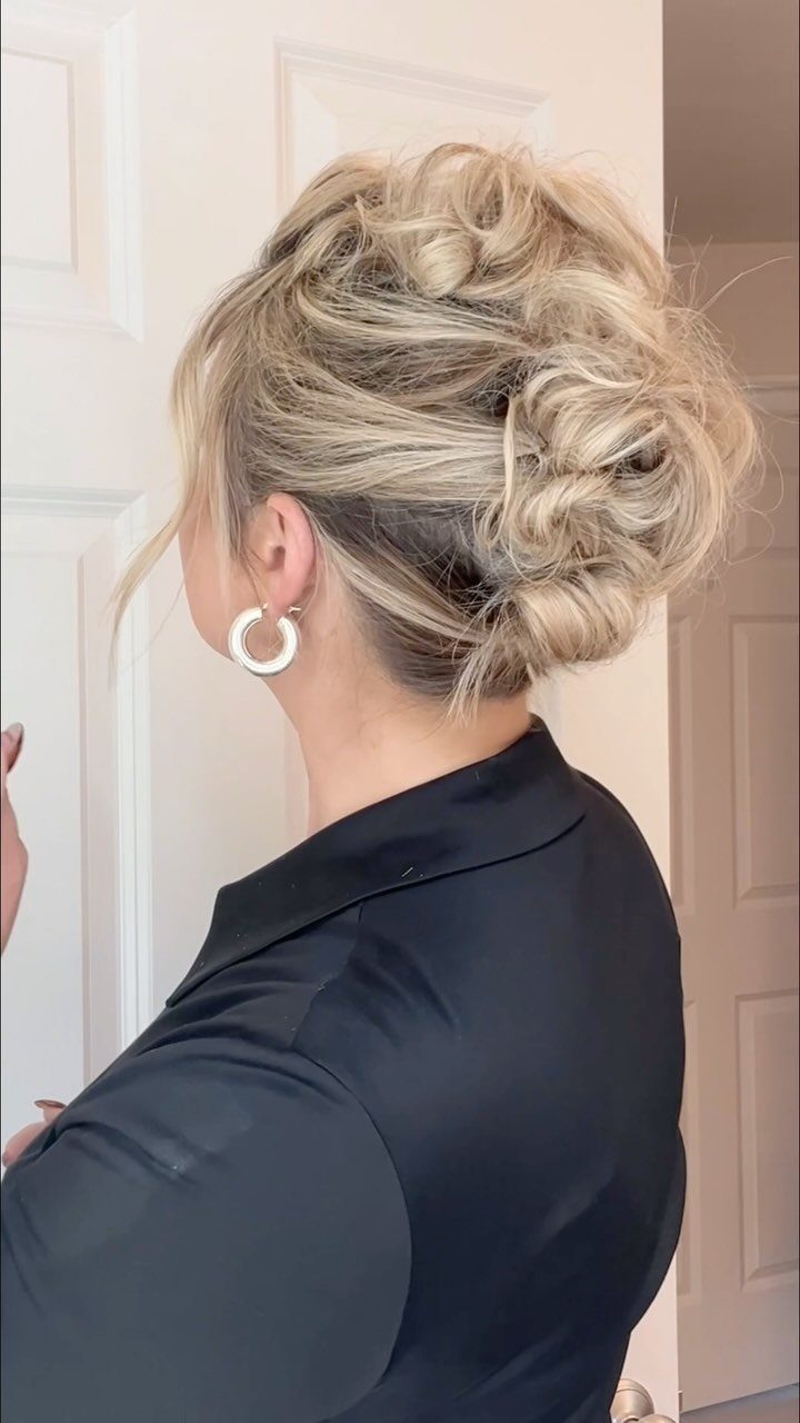 Honey blonde braided updo with curled sections and a low bun