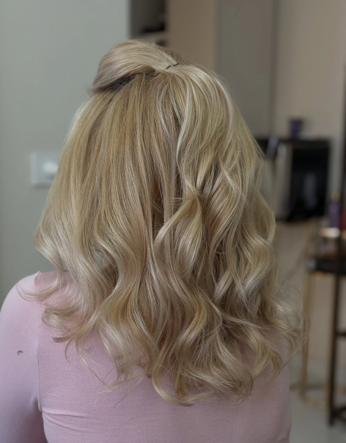 Long blonde curls show pale creamy tones blended with warm honey highlights