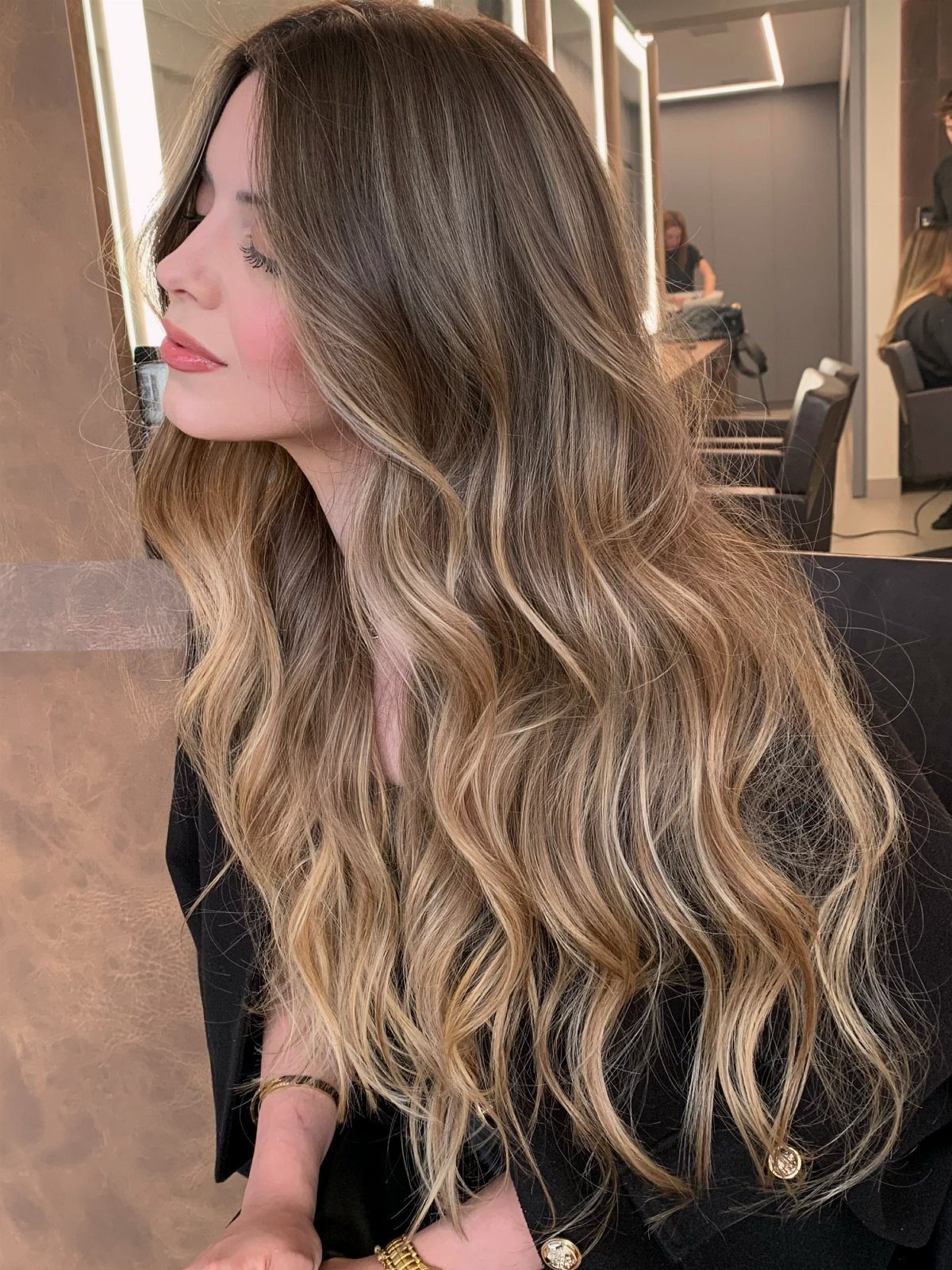 Long wavy honey-blonde hair with fine highlights and darker roots