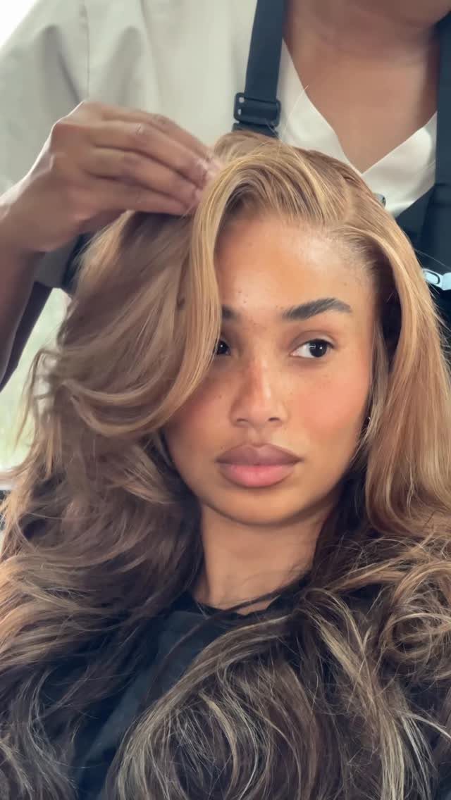 Woman with long honey blonde hair styled in loose, voluminous waves in a salon
