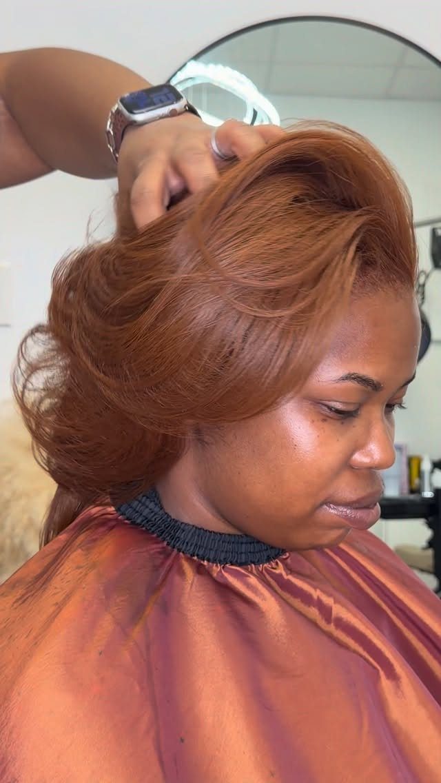 Woman showing a voluminous copper-brown bob hairstyle in a salon