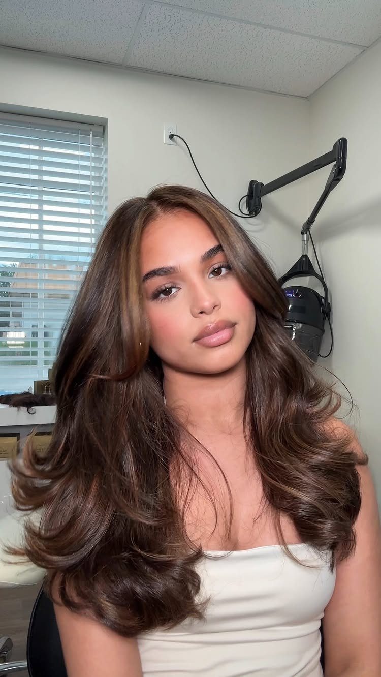 Woman showing long dark honey brown hair in voluminous loose waves