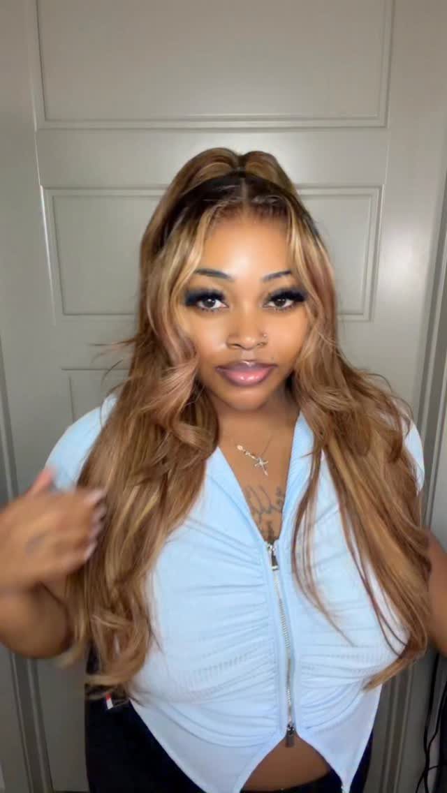Woman showing long honey-brown half-up hair with lighter face-framing strands