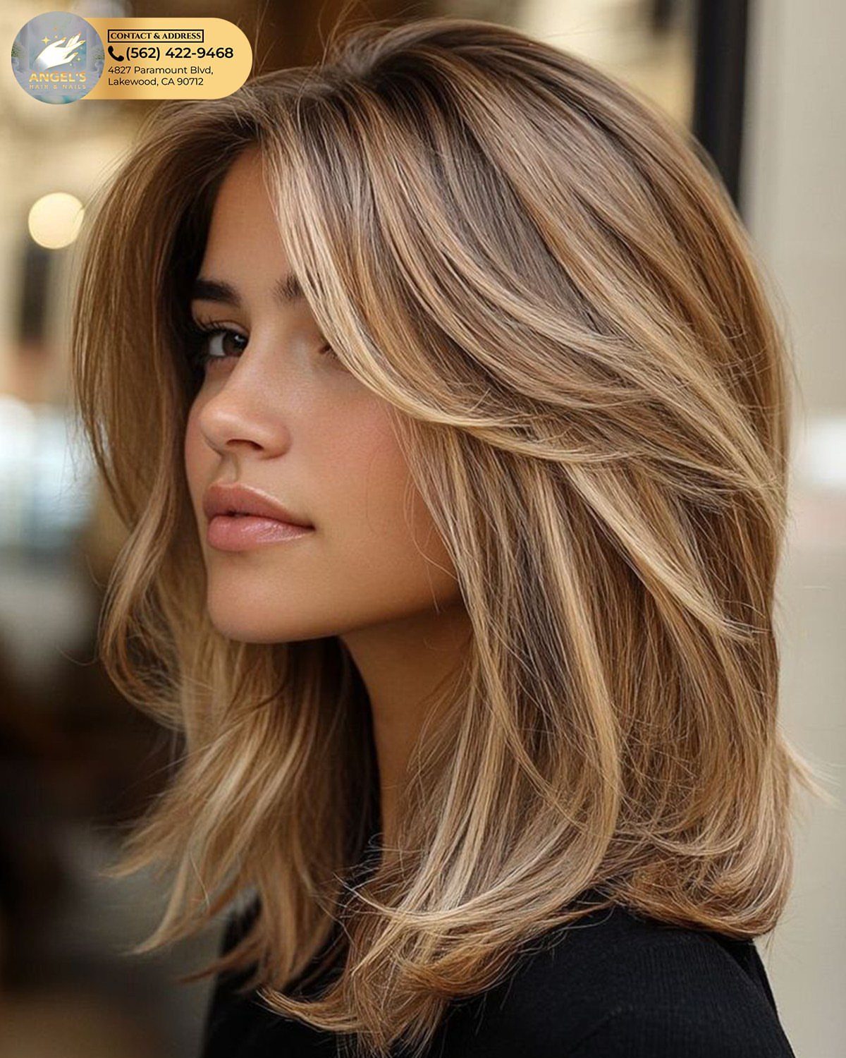 Woman with layered brunette hair and honey highlights framing her face