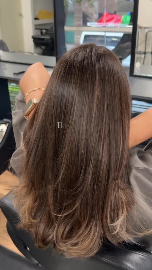 Long brunette hair with fine warm highlights and softly curled ends