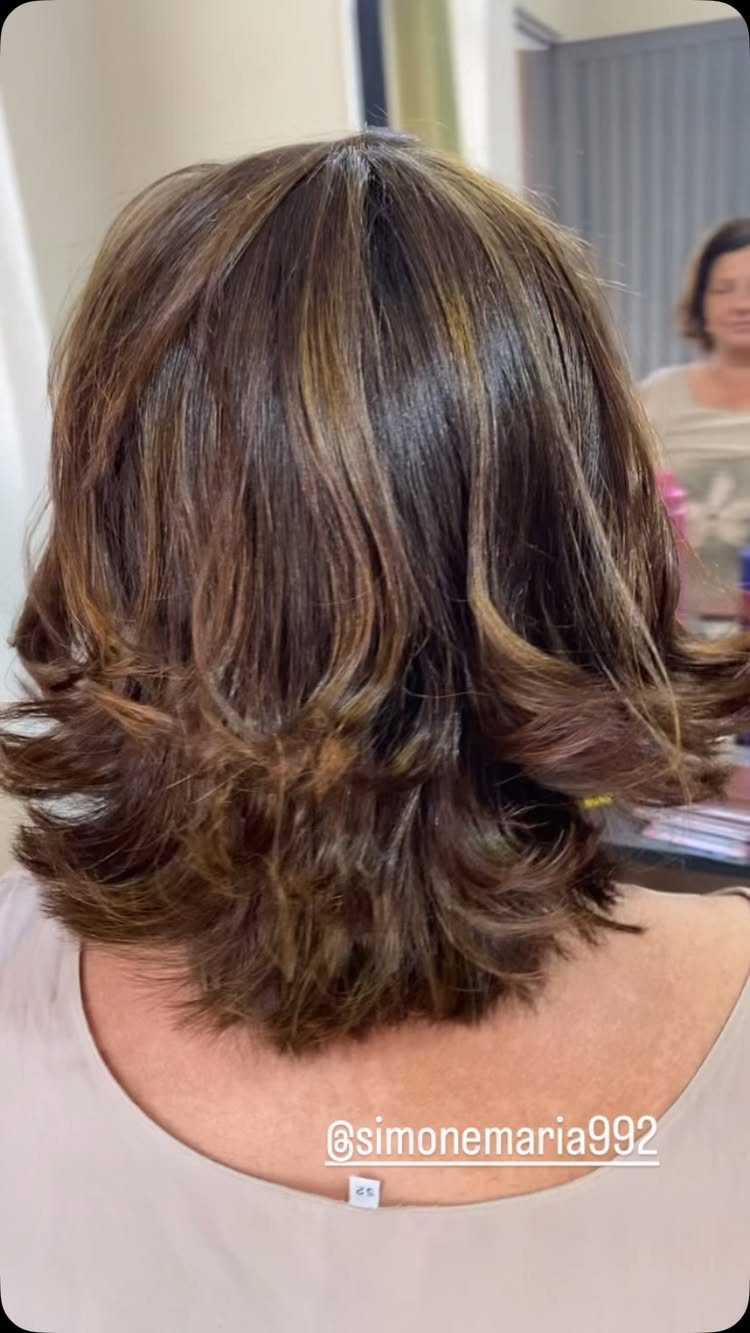 Layered brunette hair with honey-brown highlights and curled ends
