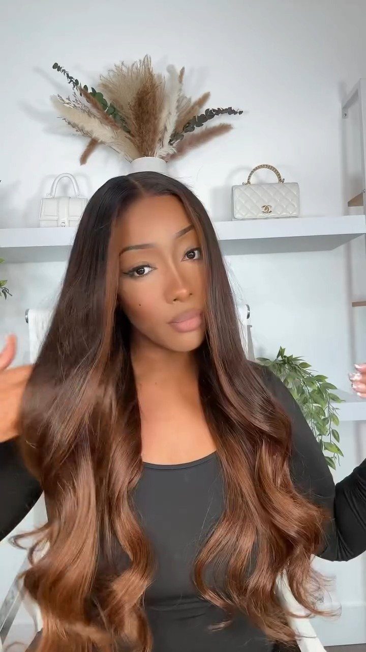 Woman displaying long rooted honey-brown hair with warm auburn waves