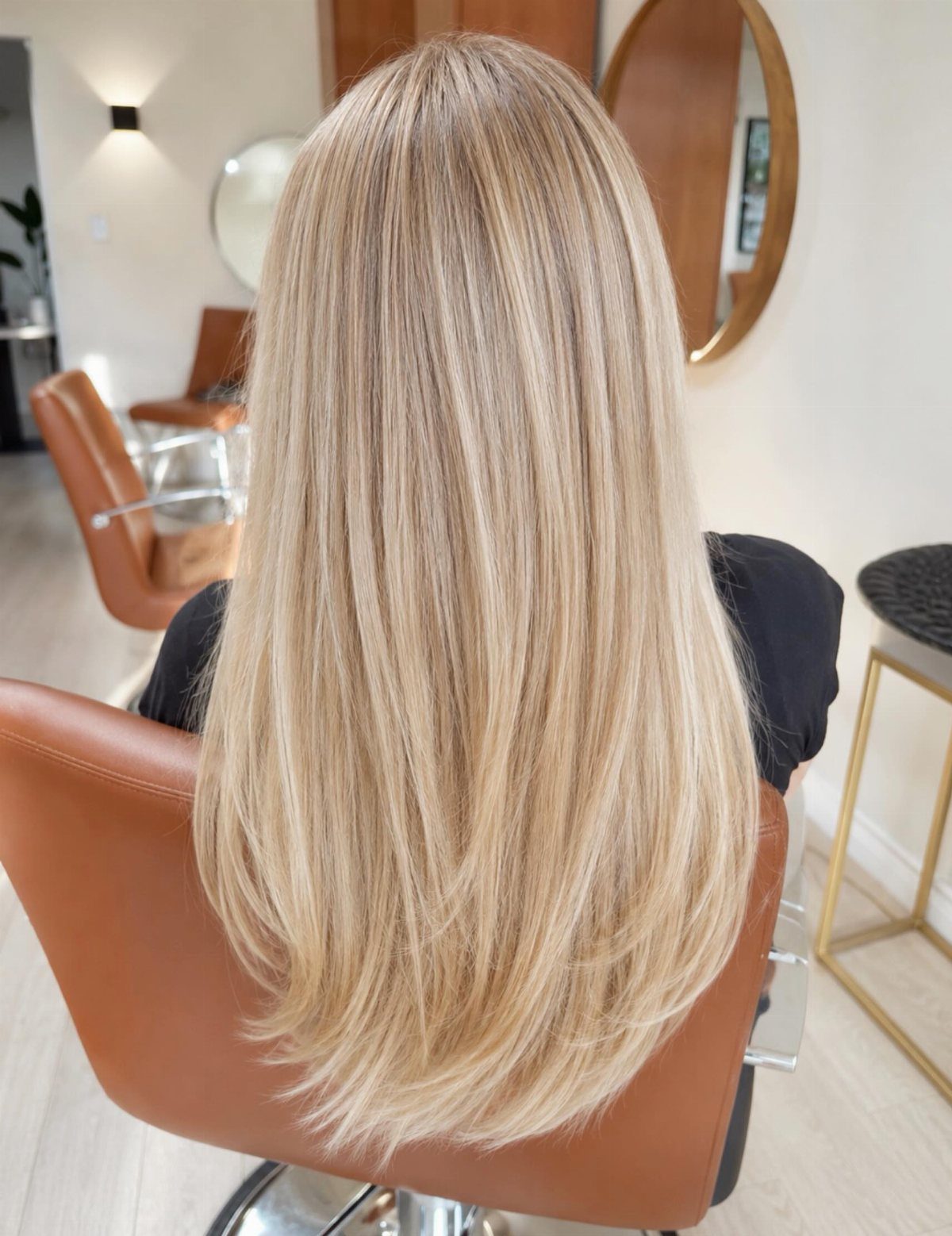 Pale blonde layered hair viewed from behind in a salon chair