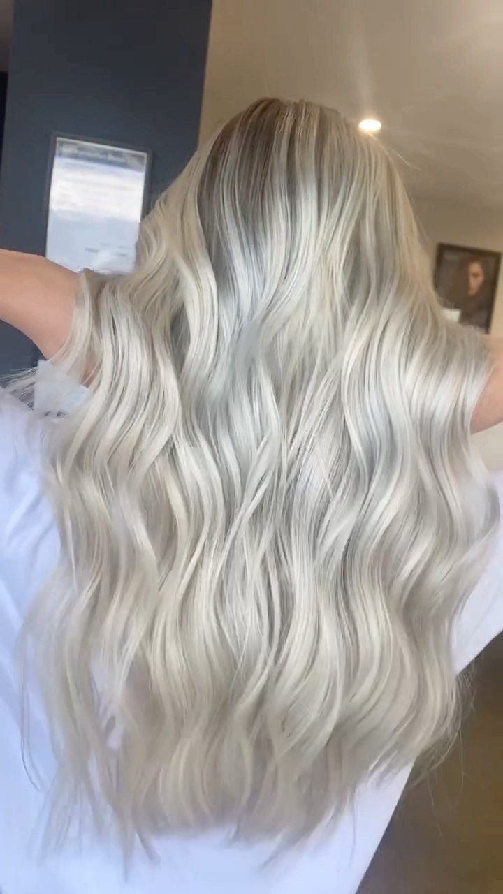 Long pearly blonde waves with darker roots shown from behind