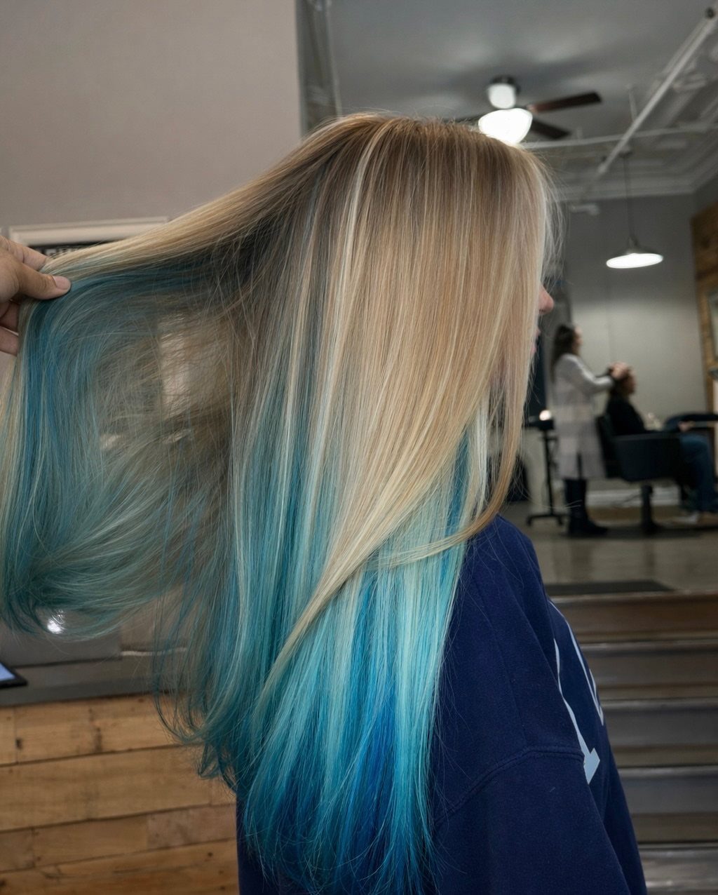 Long blonde hair with vivid blue-dipped ends displayed in a salon