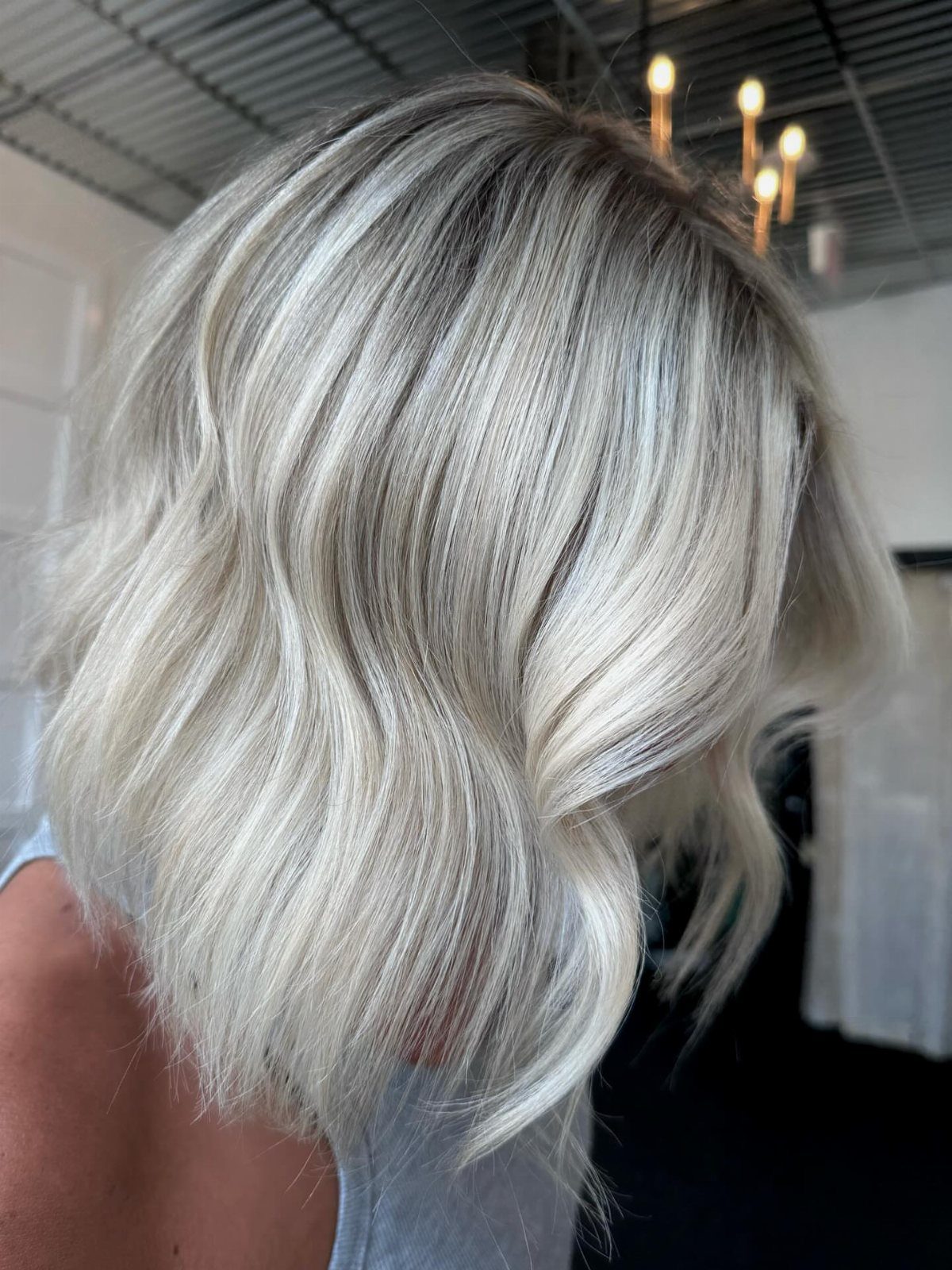 Wavy icy blonde hair with darker roots and contrasting platinum balayage
