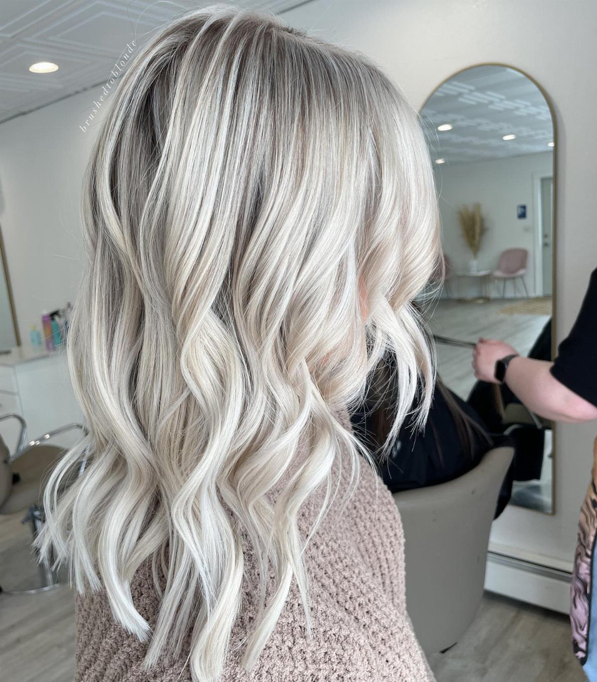 Wavy gray hair with icy blonde highlights styled in a salon