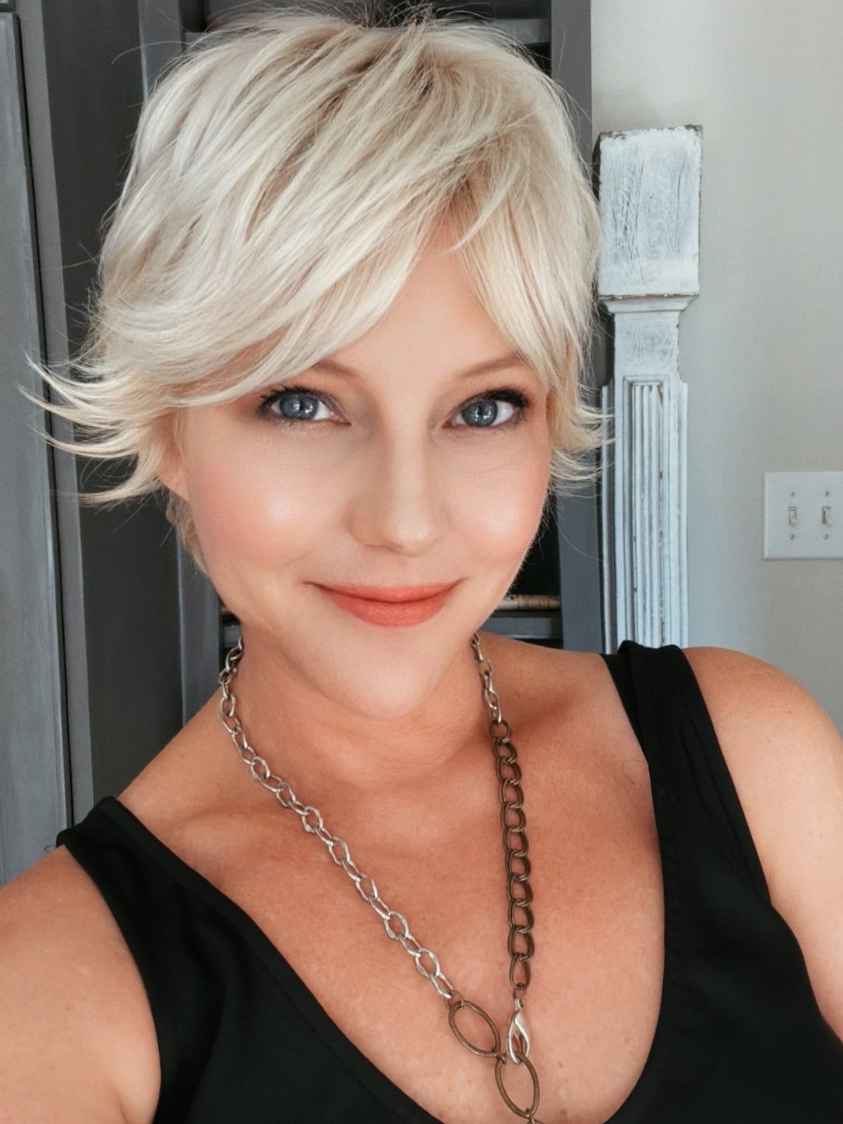 Woman with an icy blonde pixie cut and sweeping side bangs