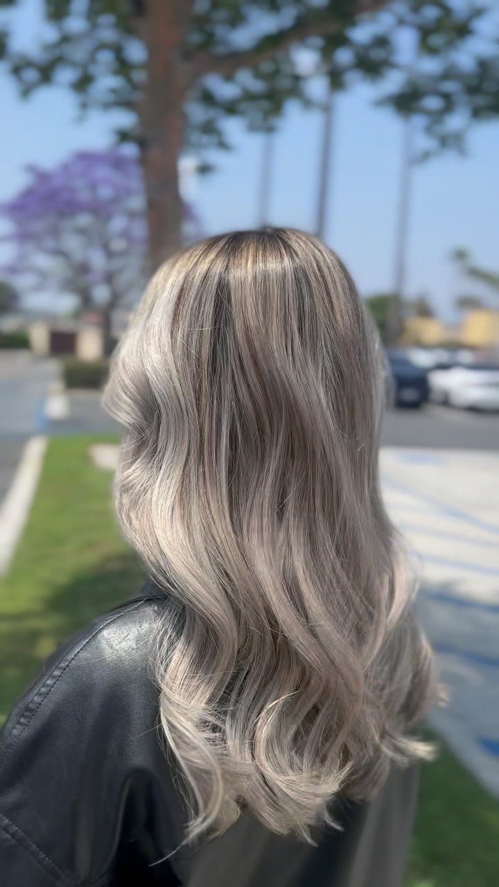 Long wavy platinum blonde hair with blended color and darker roots