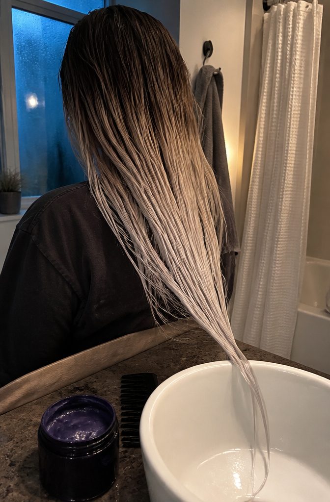 Dark roots transition across a clear line into pale icy platinum tips