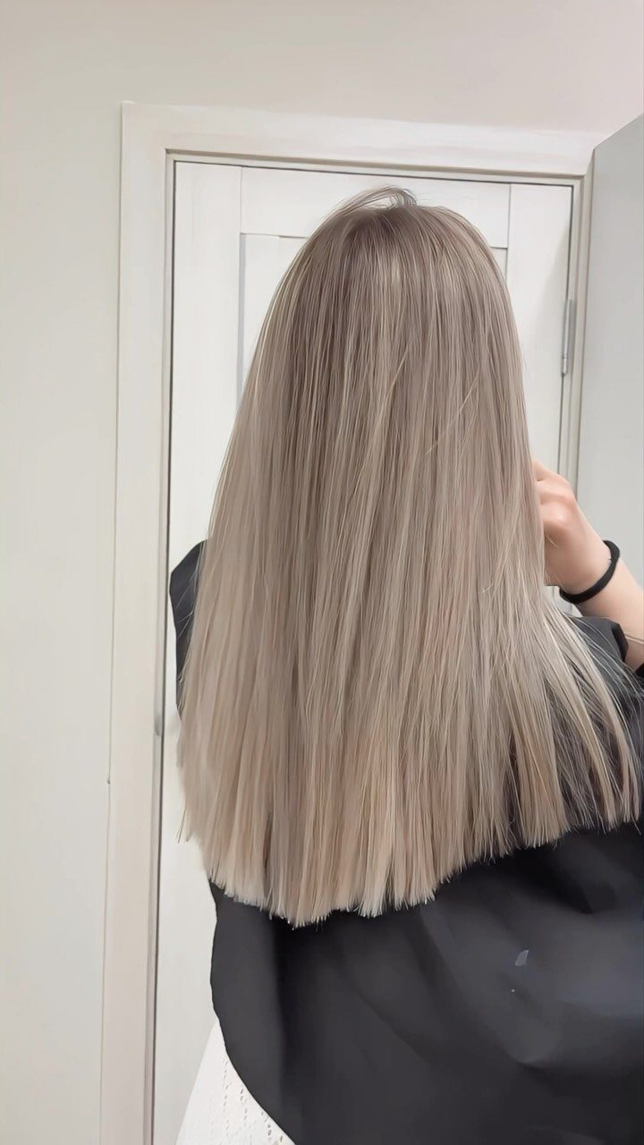 Long cool-toned level 7 blonde hair viewed from the back