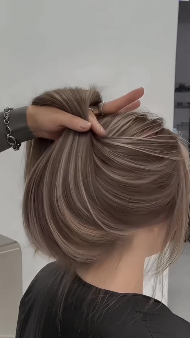 Cool-toned dark blonde hair with lighter highlights lifted to show its smooth layers