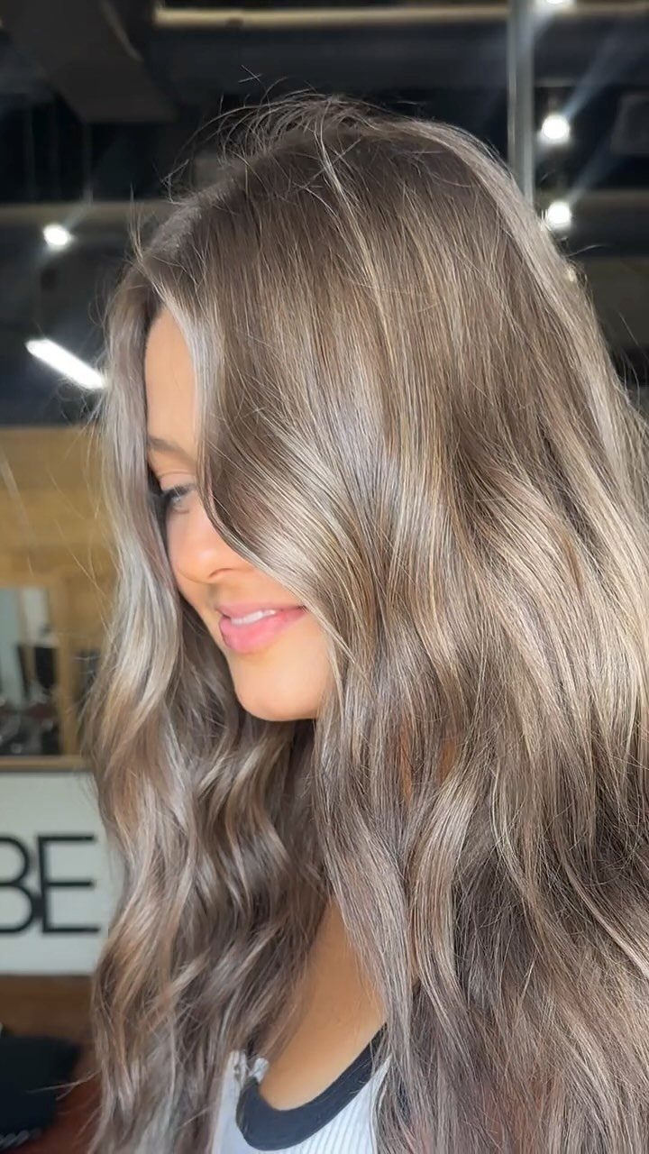 Woman showing long, wavy, cool-toned level 7 blonde hair