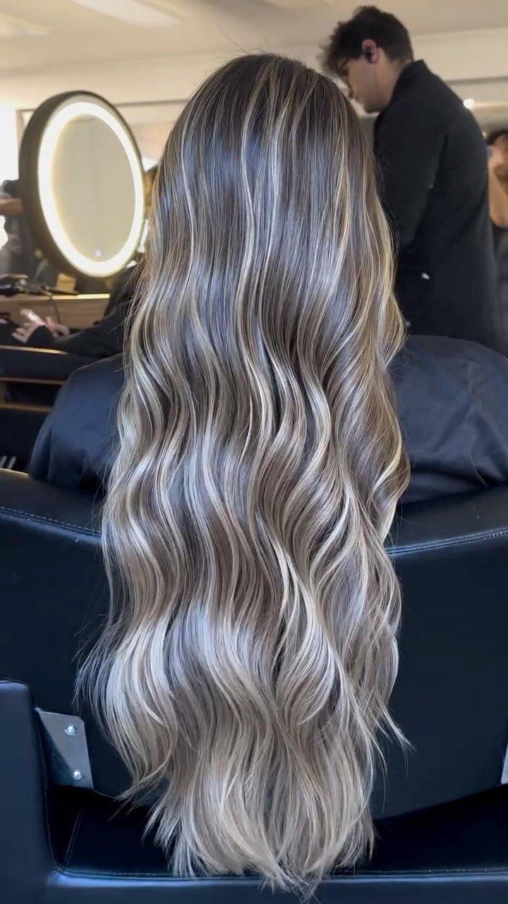Long, cool ash-blonde waves cascading down a salon client's back