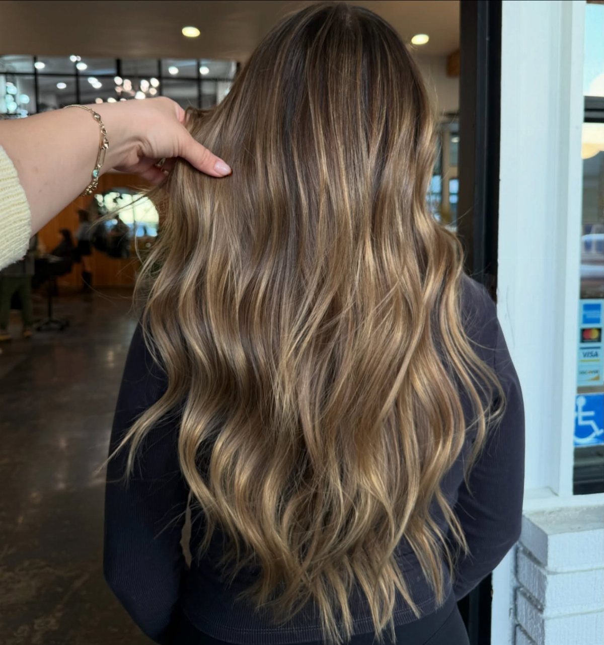 Long wavy dark blonde hair with lighter blended lengths and darker roots