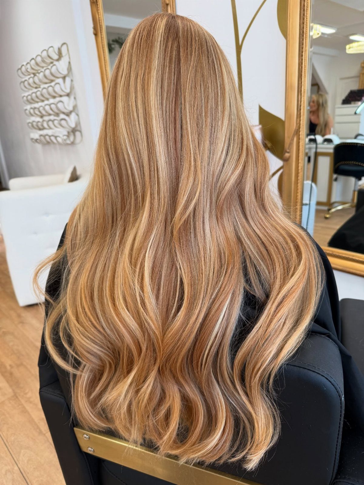 Long wavy dirty honey blonde hair with auburn highlights in a salon