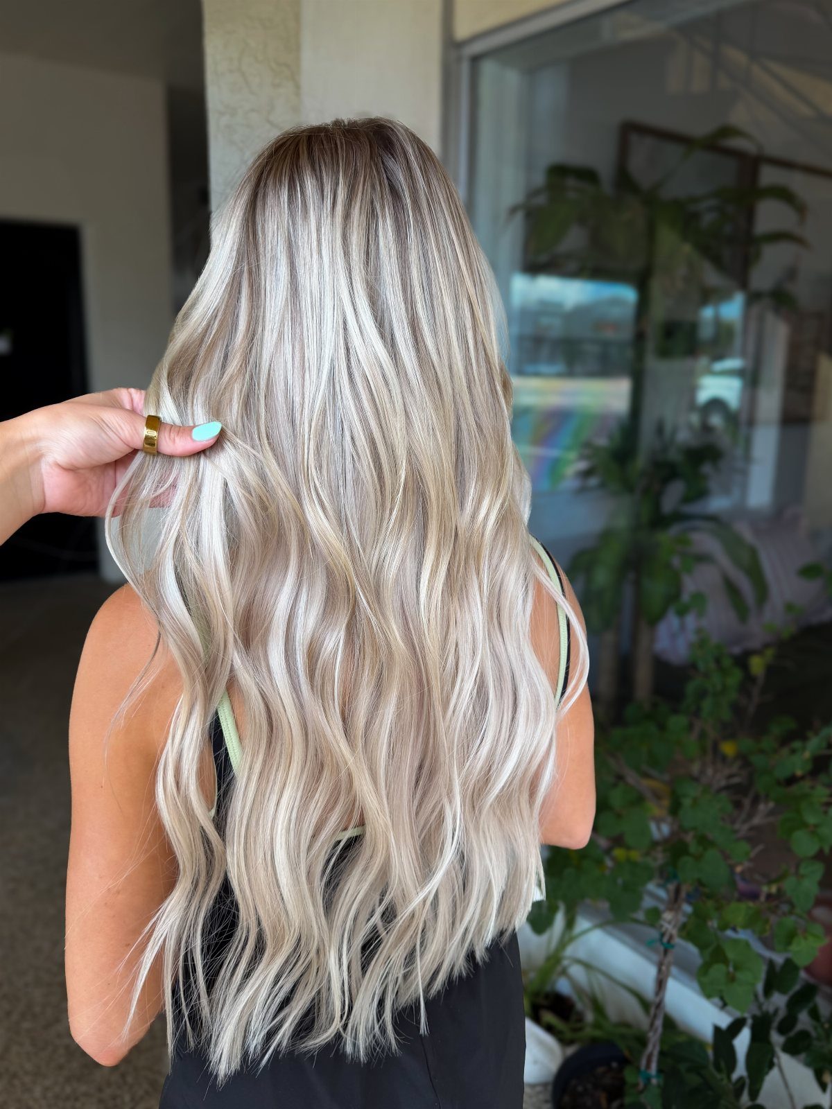 Long wavy blonde hair shows softly blended darker roots and pale lengths