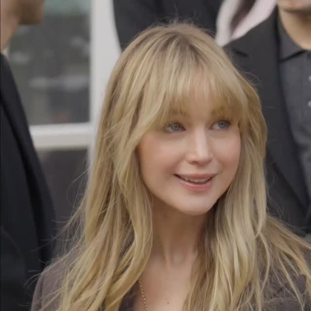 Jennifer Lawrence with long creamy blonde hair and bangs at an event
