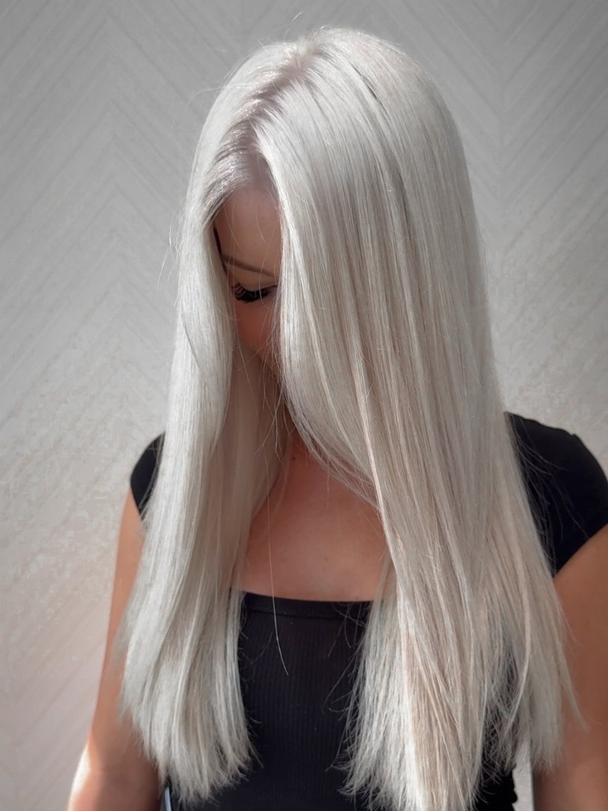 Long straight platinum blonde hair with a center part and softly layered ends