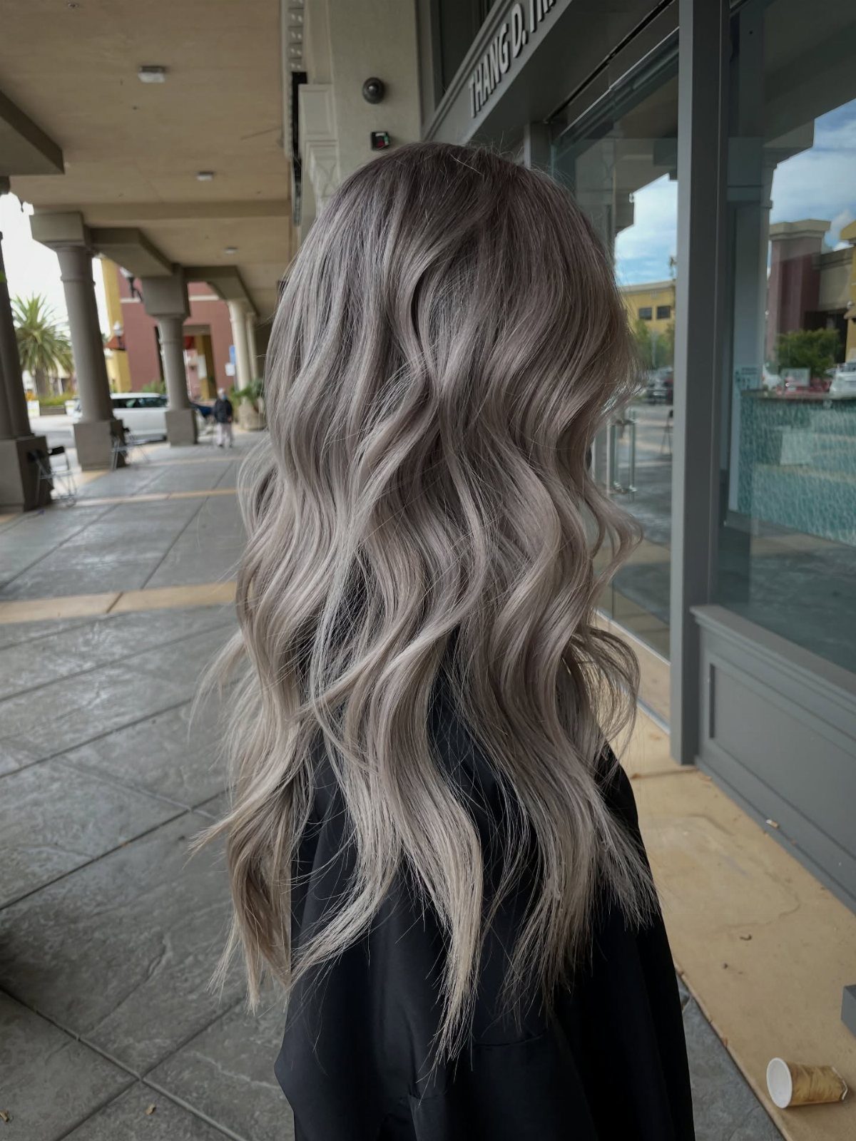 Wavy platinum hair with darker lowlights cascading over a black top