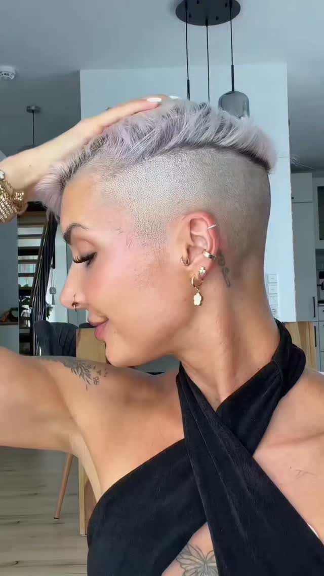 Person with pale platinum hair, shaved sides, and a longer swept top