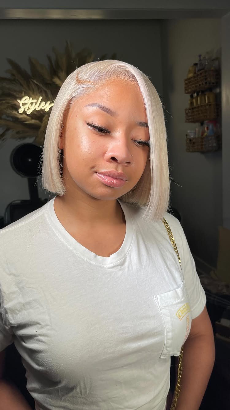 Woman posing with a sleek, chin-length platinum blonde bob and side part