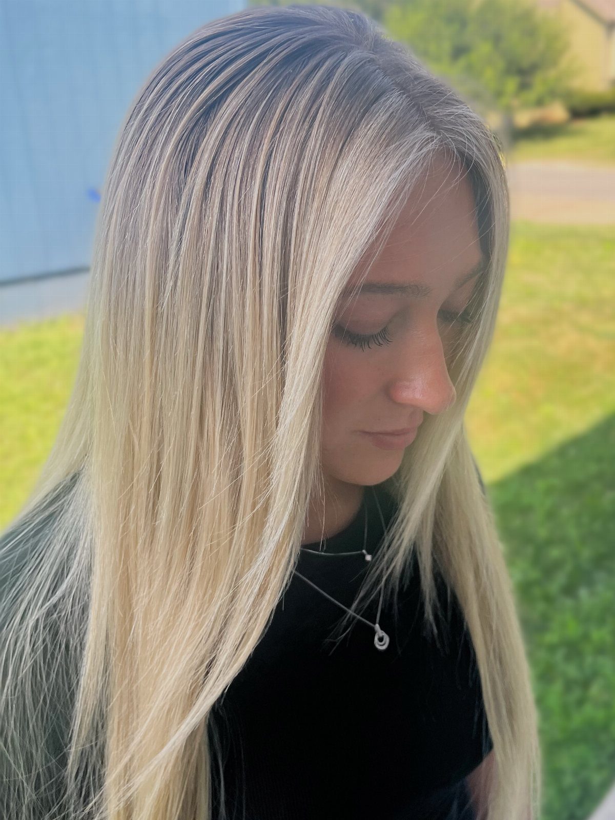 Woman with long straight dark blonde hair and platinum highlights