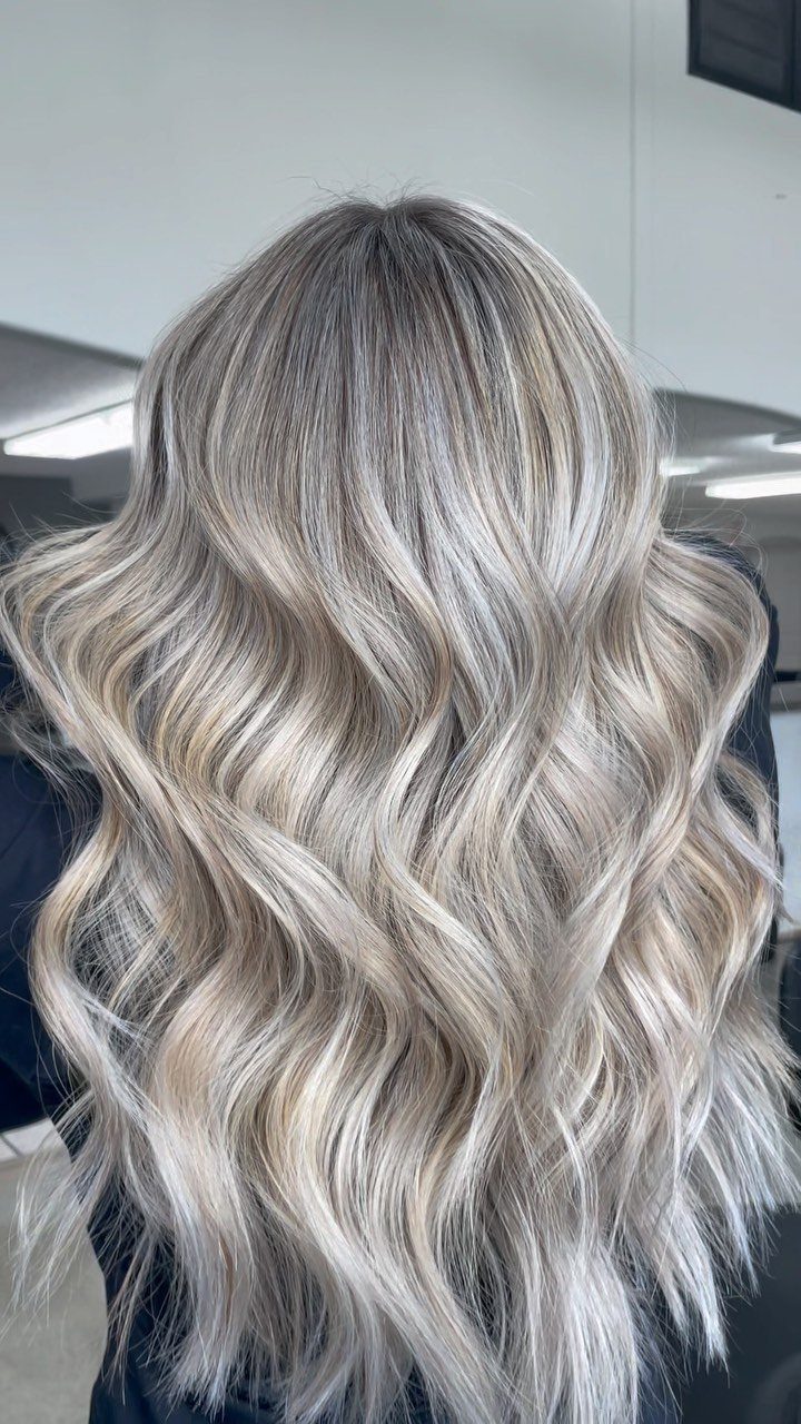 Wavy platinum blonde hair with fine highlights and darker roots