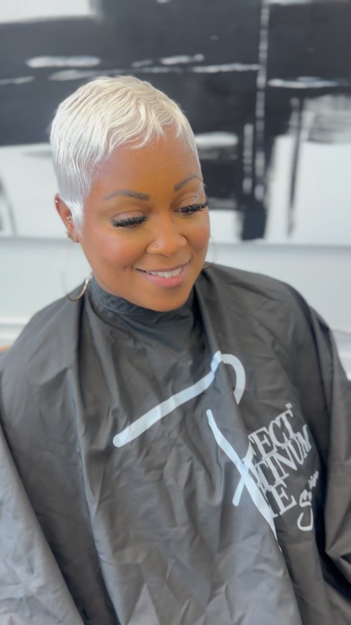 Woman showing a short platinum blonde pixie cut in a salon