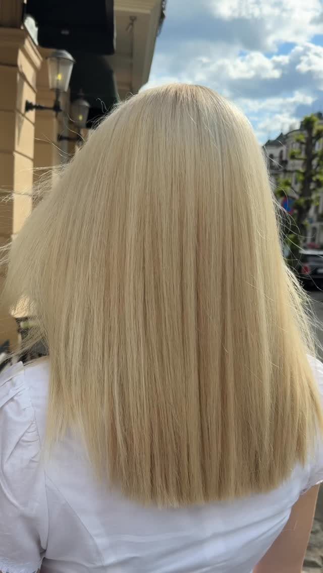 Straight pale vanilla platinum hair falls to the shoulders