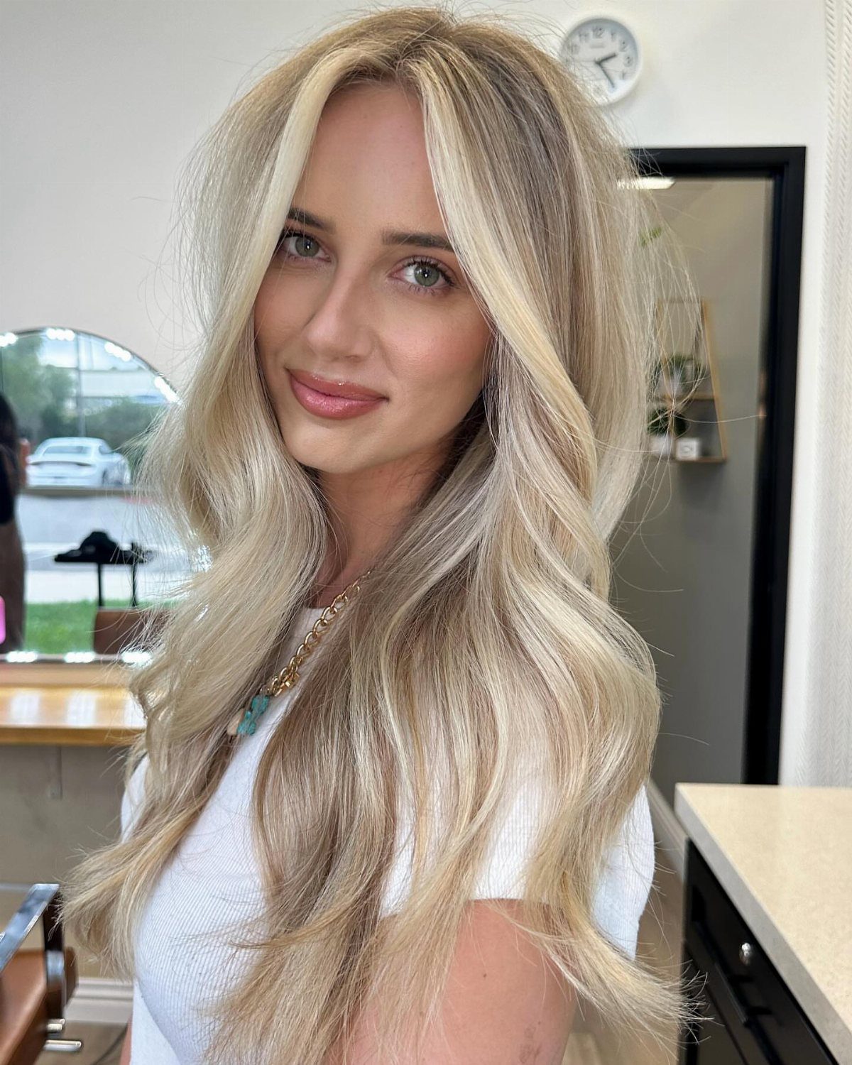 Woman showing long sandy blonde hair with bright face-framing highlights