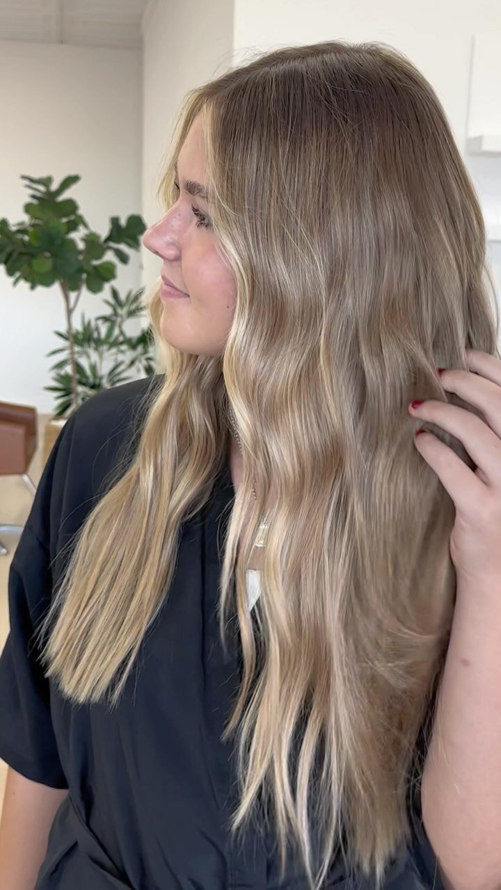 Long sandy blonde balayage hair with darker roots and softly blended lighter pieces