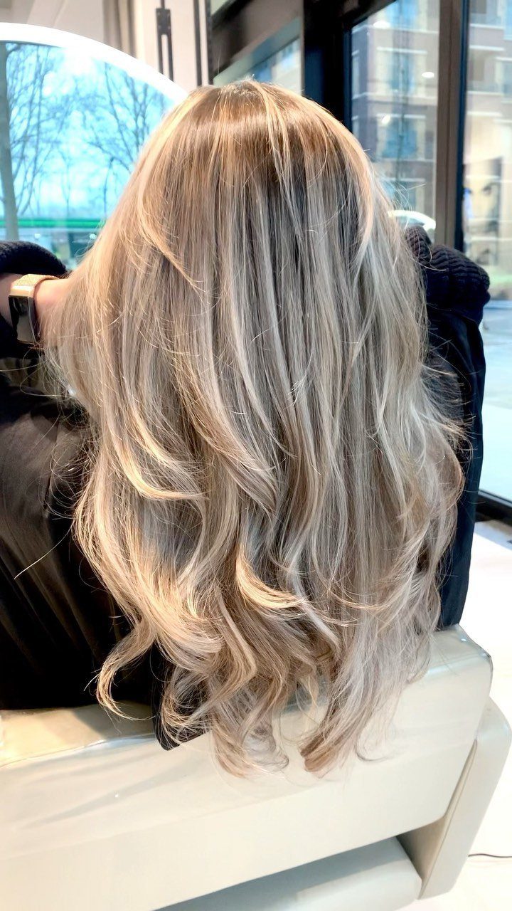 Wavy sandy blonde hair with lighter highlights and darker strands