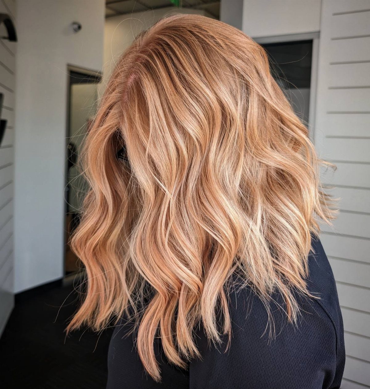 Wavy shoulder-length sandy copper blonde hair with warm, sunlit highlights