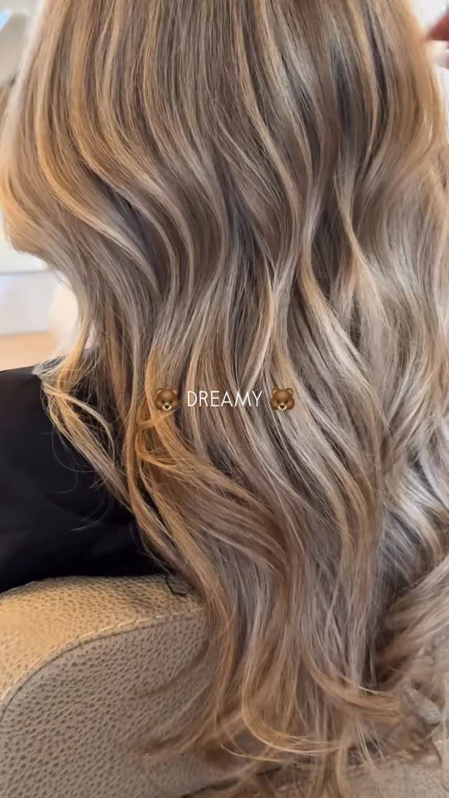 Long wavy sandy gray hair blends beige and blonde tones