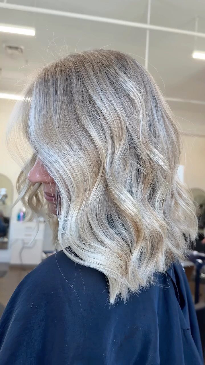 Wavy blonde hair with darker roots and contrasting pale, cool-toned strands