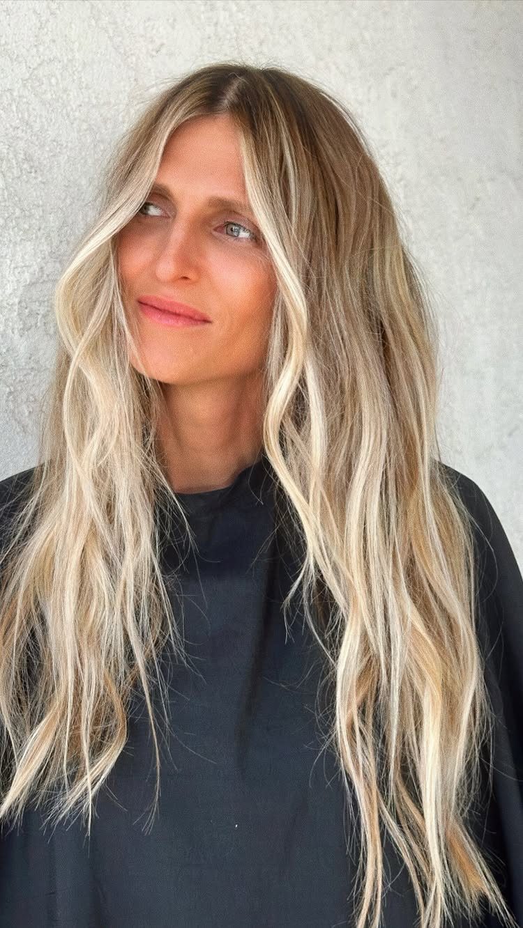 Woman with long golden blonde hair and pale face-framing highlights
