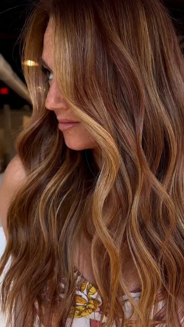 Woman with long brown waves and golden-blonde highlights