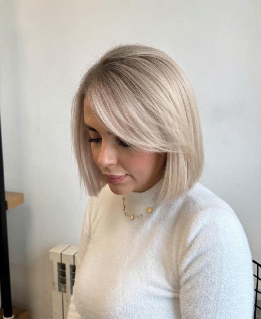 Woman with a cool blonde bob, side part, and subtle layers