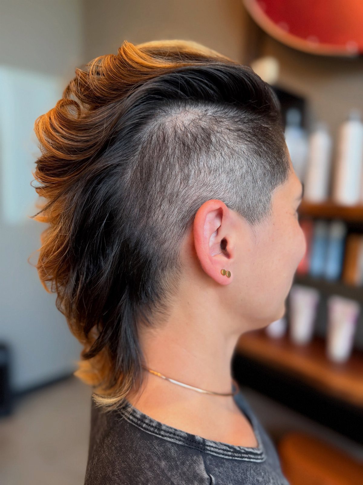 Copper-blonde swept-up hair with shaved sides and a longer nape section