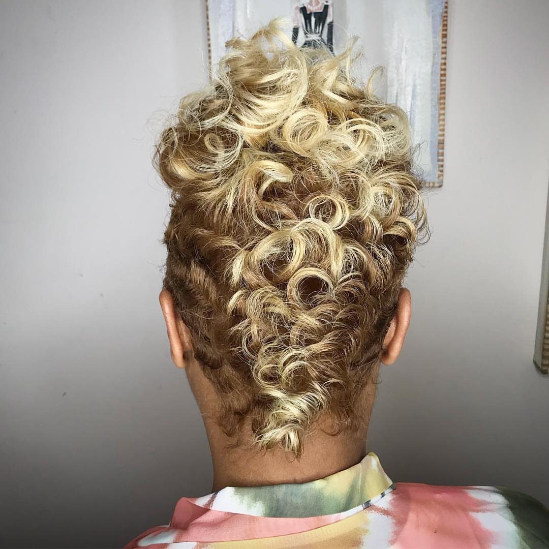 Curly blonde mohawk with closely trimmed brown sides, viewed from behind